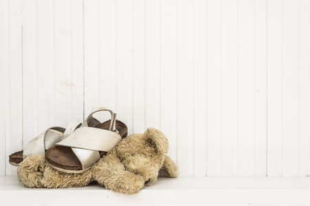 A child kidnap concept, an abandoned teddy bear and child's shoes on a floor.の写真素材