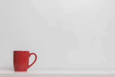A red coffee cup on table over a light background.の写真素材