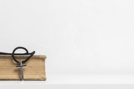 Bible and a wooden cross on table.