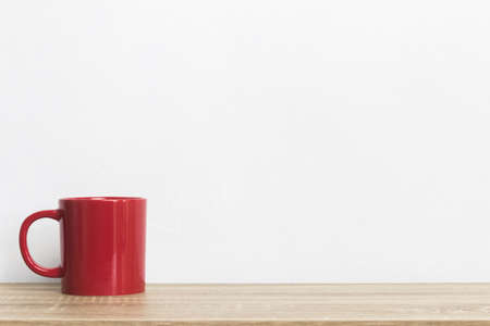 A red coffee cup on a wooden table.の写真素材