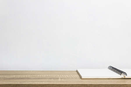A white notebook on a wooden table.