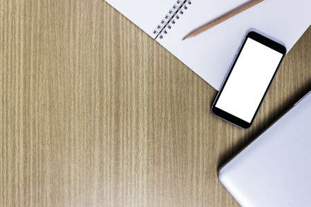A mobile phone with notebook on table.
