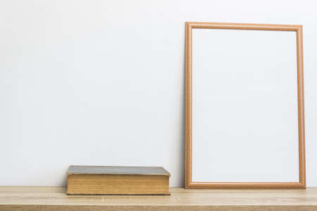 A wooden frame with book on a wooden table.の写真素材