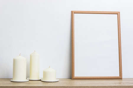 Three candles with white photo frame on wooden table with copy space.の写真素材