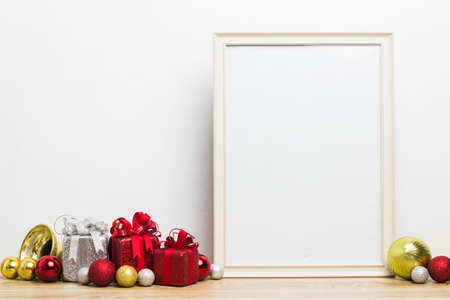 Colorful present boxes with a white photo frame on a wooden table.の写真素材