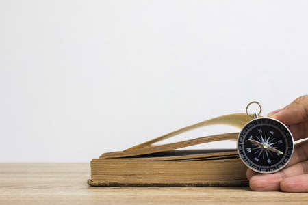 A black compass over the book with light wall.の写真素材