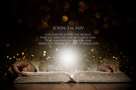 An open Bible with bible verse over the dark and gold background.