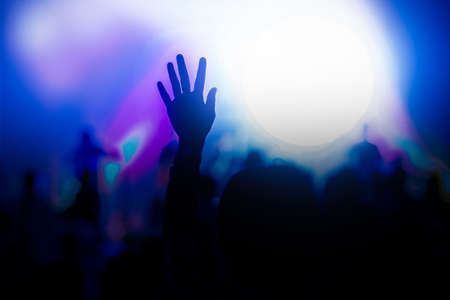 A hand up in the hair in a concert with low light.の写真素材