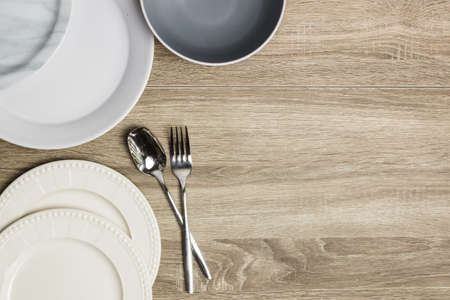 Plates with spoon and fork on a wooden table.の写真素材