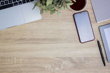 Working items with computer, keyboard and note over the wooden table.