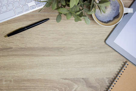 Working items with computer, keyboard and note over the wooden table.