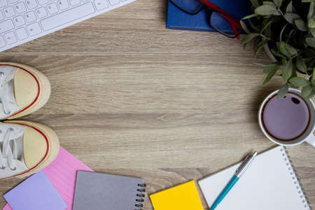 Working items with shoes and coffee on wooden table.の写真素材