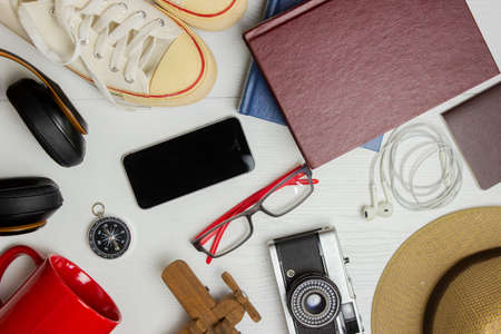 Travel concept with passport, hat, sneakers, cup, camera and books over the white background.の写真素材