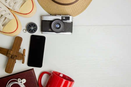 Travel concept with passport, hat, sneakers, cup, camera and books over the white background.の写真素材