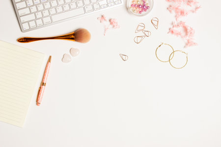 Women working space with make up blush, pink flowers, earrings over white background.の写真素材