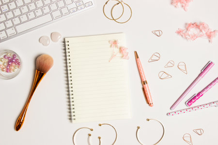 Women working space with make up blush, pink flowers, earrings over white background.の写真素材