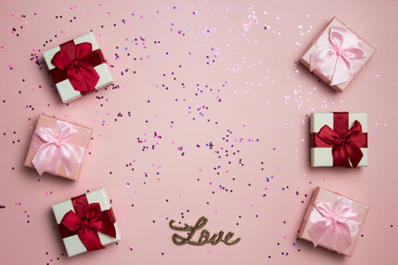 Pink gift box over the pink glitter background with copy space.