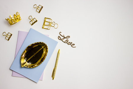 Blue and purple notebooks with golden items over the grey background.