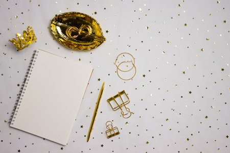 A notebook with golden items over the golden background.の写真素材