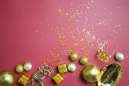 Christmas theme with golden ornaments and glitter over the red background.