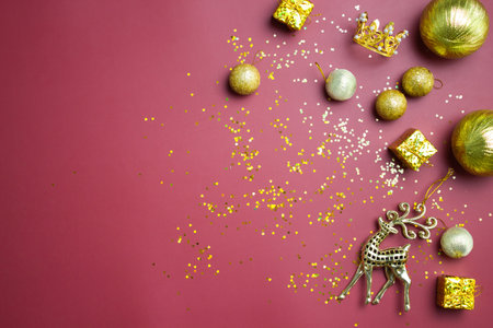Christmas theme with golden ornaments and glitter over the red background.の写真素材
