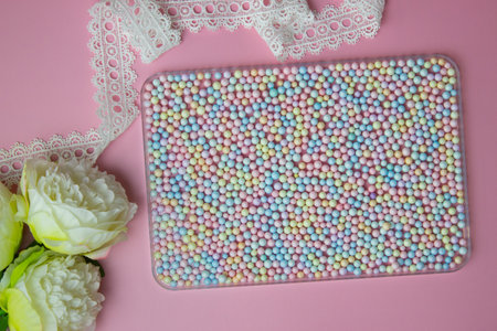 Colorful balls, white flowers and ribbon over the pink background.の写真素材