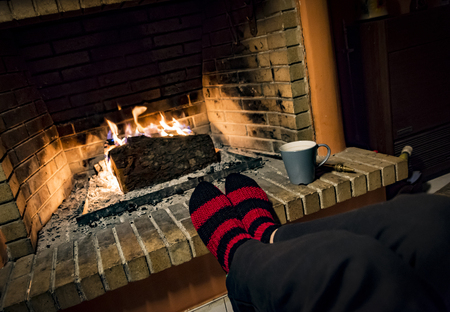 womans feet while she is warming in a fireplaceの写真素材