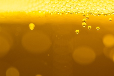 Macro shot of drops of beer inside a glassの写真素材