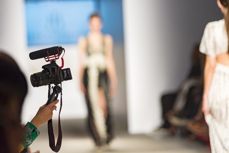 people from audience filming them self in a fashion showの写真素材