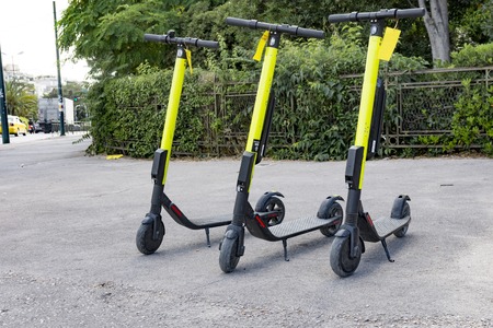 few electric scooters parked waiting for someone to pick them