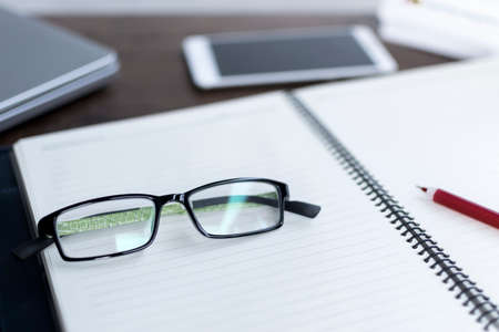 Office shot with laptop, phone and eyglassesの写真素材