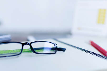 Office shot with eyeglasses, pen, diaryの写真素材