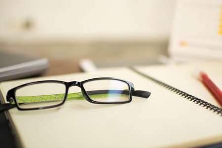 Eyeglass and pen on tableの写真素材