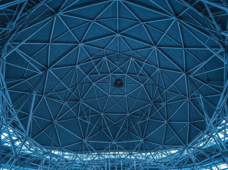 A detailed view of the intricate metal framework supporting a large dome-shaped structure. The geometric patterns and symmetrical design create a visually striking and modern architectural scene.の素材