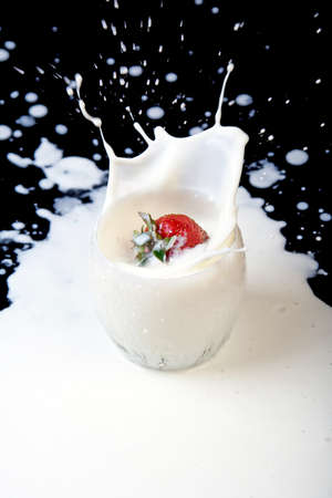 Strawberry in milk splash on dark backgroundの写真素材