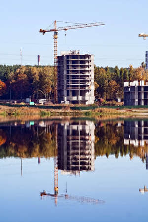 Crane and building reflection in the lakeの写真素材