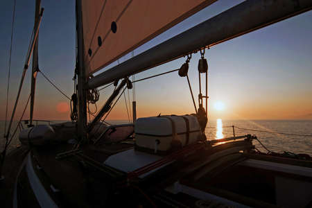 Sailing boat in the sea at sunset