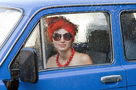 Vintage girl driving car under rain
