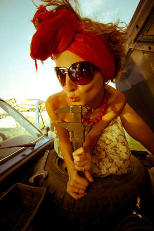 Vintage girl with tool repairing carの写真素材