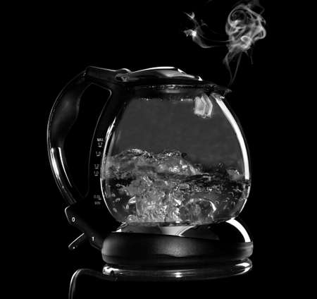 Kettle with boiling water and steam isolated with clipping path on black background