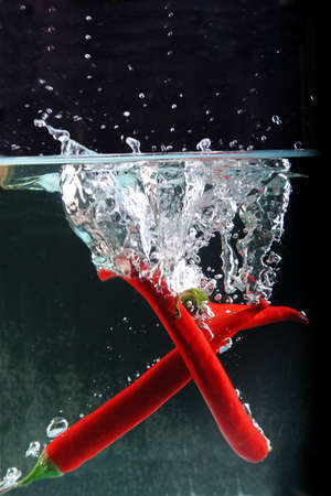 Chili in water splash の写真素材