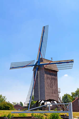 Old windmill in the field, green grass, blue skyの写真素材