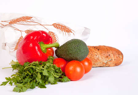 Pile of ripe vegetables with waterdrops and baguette in paper bag isolated on white backgroundの写真素材
