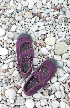 Woman shoes lying on the beach stonesの写真素材