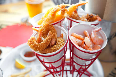 Set of shrimps, boiled, grilled, fried with lemon and tomato sauceの写真素材