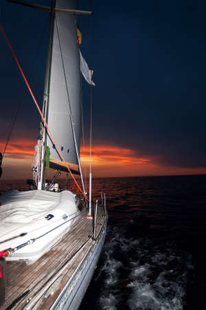 Sailing boat in the sea at sunsetの写真素材