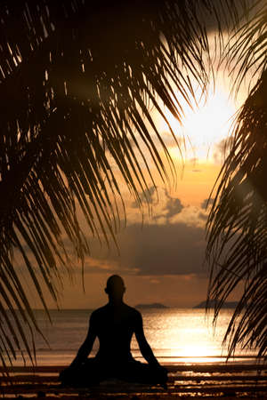Man silhouette doing yoga exercise at sunset beach

の写真素材