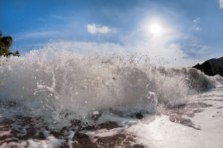Big wave front with bubbles and splashes closeup viewの写真素材