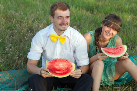 Young couple eating watermelon at picnic
の写真素材