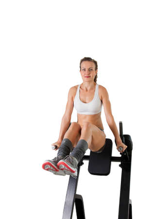 Athletic young woman training press on exerciser isolated on white